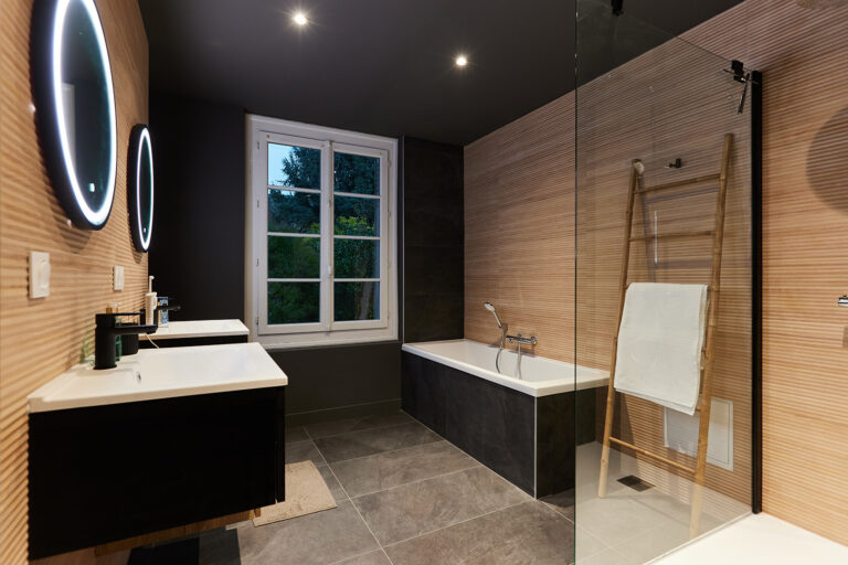 Rénovation d'une salle de bain en carrelage foncé et en bois