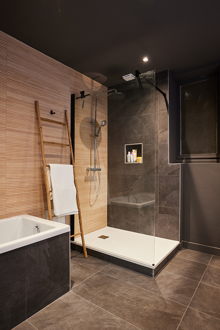 Rénovation d'une salle de bain en carrelage foncé et en bois